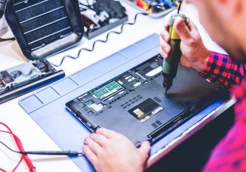 IT engineer technician repairing computer in electronics service shop