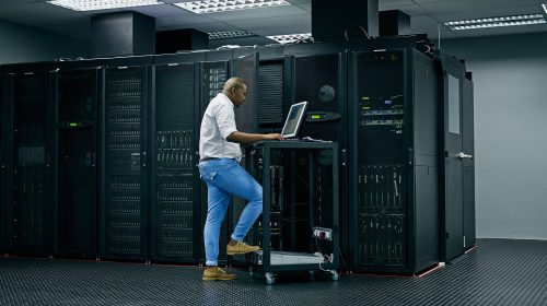 Skilled in all things IT. Shot of an IT technician using a computer while working in a data center.